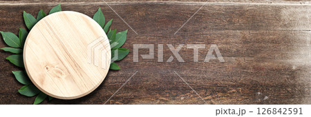 Horizontal banner with green leaves and wooden round plate on boards. Ecology, global wildlife resource, eco, go green, forest protect concept. Environmental and conservation protection background Horizontal banner with green leaves and wooden round plate on boards. Ecology, global wildlife resource, eco, go green, forest protect concept. Environmental and conservation protection background 126842591