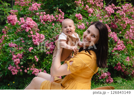 Joyful Mother and Baby in Blooming Garden 126843149
