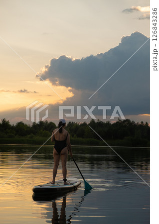 Paddleboarding at Sunset on a Tranquil Lake 126843286