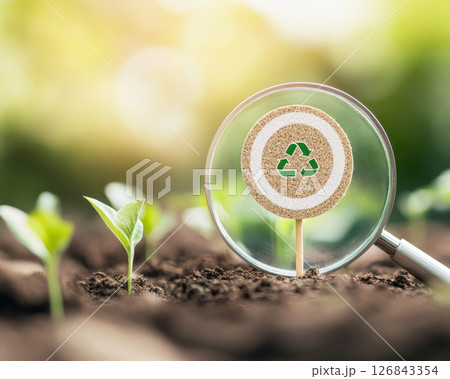 magnifying glass focuses on target board with recycling symbol, symbolizing sustainability and environmental awareness 126843354