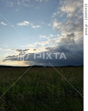 Dramatic Sunset Over Grassy Field Dramatic Sunset Over Grassy Field 126843419