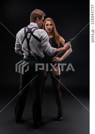 Mysterious encounter between a man and a woman in dark setting with suspense Mysterious encounter between a man and a woman in dark setting with suspense 126843737