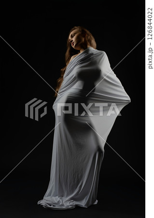 Model posing gracefully in flowing fabric during casting session 126844022