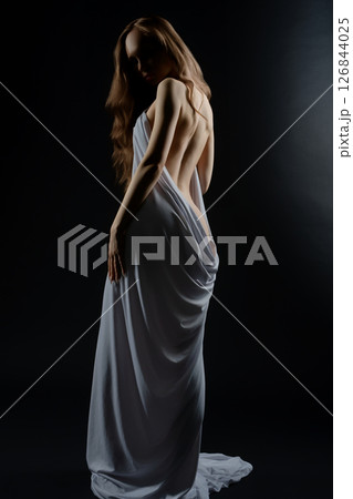 Woman posing beautifully in a dramatic casting session under soft lighting Woman posing beautifully in a dramatic casting session under soft lighting 126844025