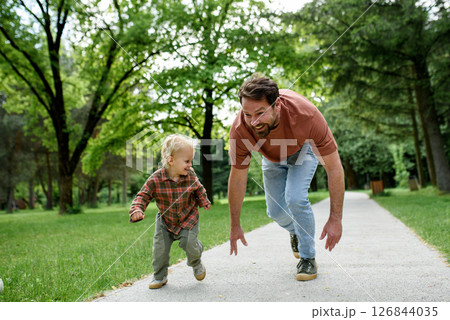 Father lining up to have a running race with his little son. 126844035