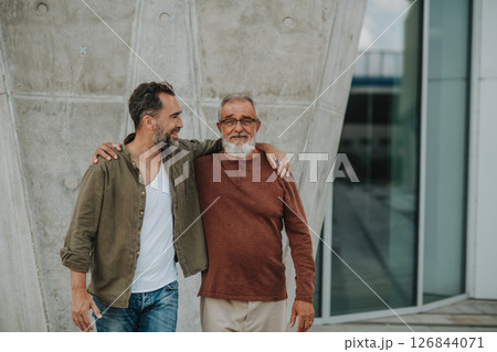 Portrait of handsome mature man and his older father hugging each other. Portrait of handsome mature man and his older father hugging each other. 126844071