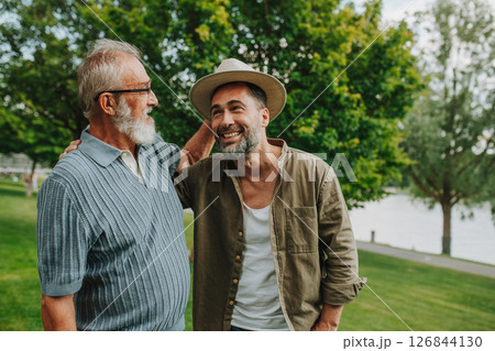 Father and adult son sharing a joyful moment outdoors 126844130