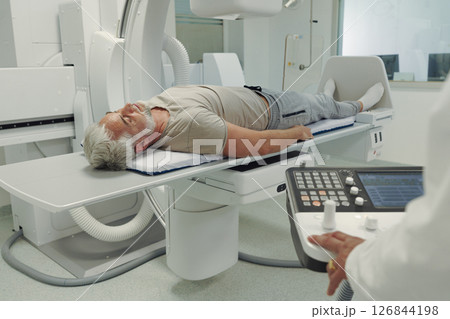 Doctor operationg CT machine in hospital. Doctor operationg CT machine in hospital. 126844198