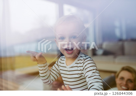 Cute boy looking out of window, laughing. 126844306