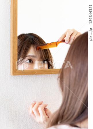 前髪を気にしている女性① 126844521