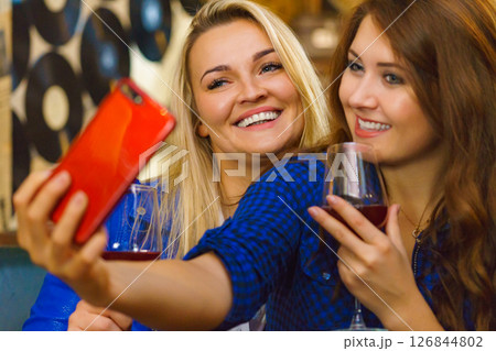 Girls in pub club taking self photo with phone 126844802