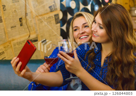 Girls in pub club taking self photo with phone 126844803