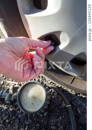 クルマのタイヤのバルブキャップを取り外す クルマのタイヤのバルブキャップを取り外す 126845129