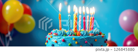 Colorful birthday cake with candles surrounded by balloons and decorations for a joyful celebration Colorful birthday cake with candles surrounded by balloons and decorations for a joyful celebration 126845880