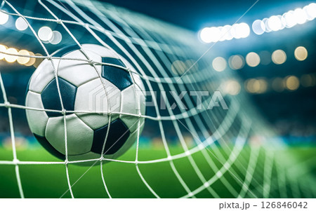Soccer ball in net during night stadium game, representing football championship, victory, match excitement, competition, sports event, teamwork, athlete performance, dynamic action 126846042
