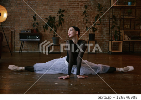 A graceful ballerina in an artistic pose captured beautifully in her home studio environment 126846988