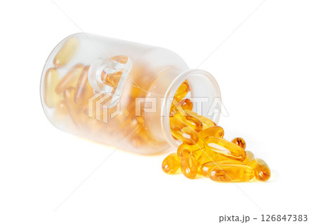 Frosted glass jar tipped over with golden fish oil softgel capsules spilling out isolated on white background Frosted glass jar tipped over with golden fish oil softgel capsules spilling out isolated on white background 126847383