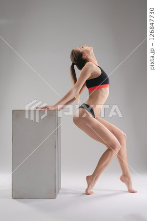 Woman in a sporty pose showcasing athleticism in a studio setting Woman in a sporty pose showcasing athleticism in a studio setting 126847730