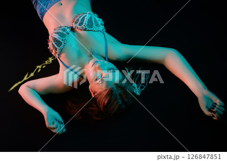 Woman posing as a mermaid in a creative body art cosplay setting Woman posing as a mermaid in a creative body art cosplay setting 126847851