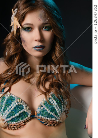 Woman poses as a mermaid in intricate body art and cosplay attire Woman poses as a mermaid in intricate body art and cosplay attire 126847852