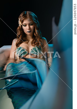 Woman posing as a mermaid in body art at a cosplay event in a studio 126847853