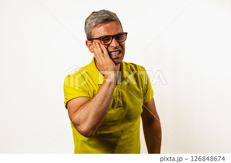 Man with tooth pain against a plain background Man with tooth pain against a plain background 126848674
