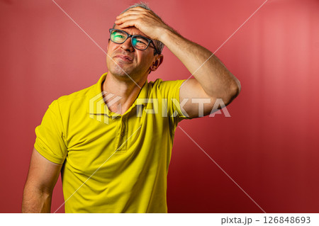 Man expresses frustration against a red background 126848693