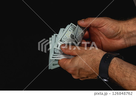 Hands counting cash in low light setting Hands counting cash in low light setting 126848762