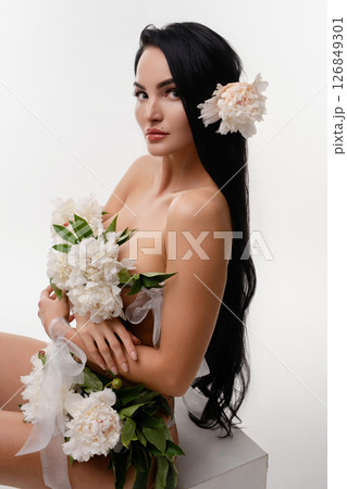 Brunette beauty adorned with flowers in a serene natural setting 126849301