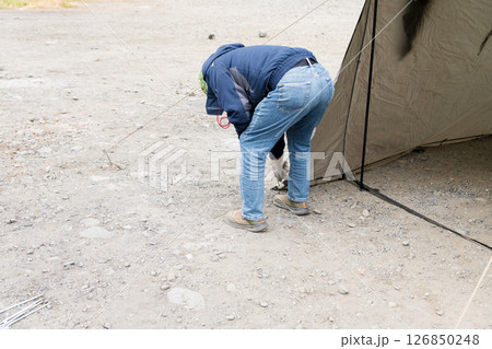 【中津川河川敷でオートキャンプ　テントスカート部分のペグを抜き撤収準備】 126850248