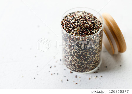 Mix of white, black and red quinoa seeds in glass jar. 126850877