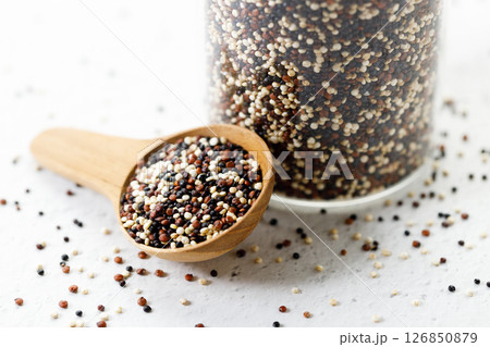 Mix of white, black and red quinoa seeds in wooden spoon. Mix of white, black and red quinoa seeds in wooden spoon. 126850879