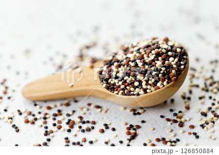 Mix of white, black and red quinoa seeds in wooden spoon. Mix of white, black and red quinoa seeds in wooden spoon. 126850884