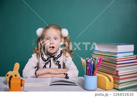 Surprised Child with Books and School Supplies Surprised Child with Books and School Supplies 126852610