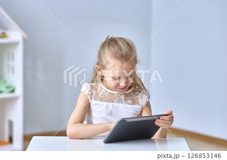 Young Girl Engaged with Tablet Technology. Copy space Young Girl Engaged with Tablet Technology. Copy space 126853146