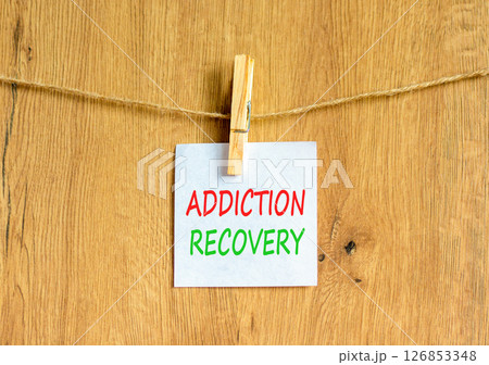Addiction recovery symbol. Concept words Addiction recovery on beautiful white paper on clothespin. Beautiful wooden background. Psychology addiction recovery concept. Copy space. 126853348