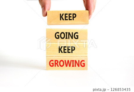 Keep going and growing symbol. Concept words phrase Keep going keep growing on beautiful wooden blocks. Beautiful white background. Businessman's hand. Business Keep going growing concept. Copy space. 126853435