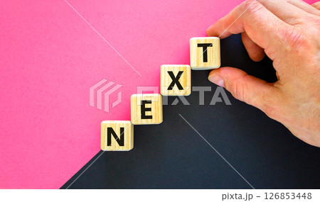 Next symbol. Concept word Next on beautiful wooden blocks. Businessman hand. Beautiful black and purple background. Business, lifestyle, support and next concept. Copy space. Next symbol. Concept word Next on beautiful wooden blocks. Businessman hand. Beautiful black and purple background. Business, lifestyle, support and next concept. Copy space. 126853448