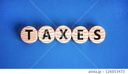 Taxes symbol. Concept word Taxes on beautiful wooden circles. Beautiful blue table blue background. Business lifestyle taxes concept. Copy space. 126853473
