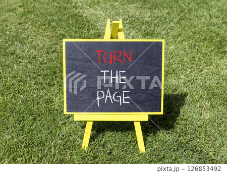 Turn the page symbol. Concept words Turn the page on beautiful yellow blackboard. Beautiful green grass lawn background. Business motivational lifestyle turn the page concept. Copy space. 126853492