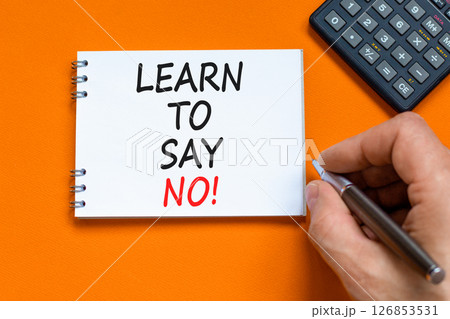 Learn to say no symbol. Concept words phrase Learn to say no on beautiful white note. Businessman's hand. Beautiful orange background. Business psychological Learn to say no concept. Copy space. 126853531