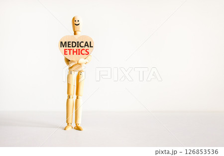 Medical ethics symbol. Concept words Medical ethics on beautiful wooden heart. Doctor's model. Beautiful white background. Copy space. Medical healthy lifestyle medical ethics concept. 126853536