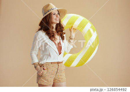 smiling elegant woman in blouse and shorts on beige 126854492