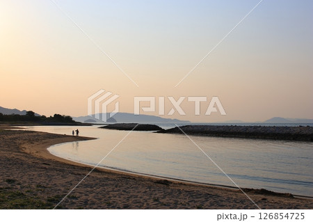 夕方の海岸で散歩する親子 126854725