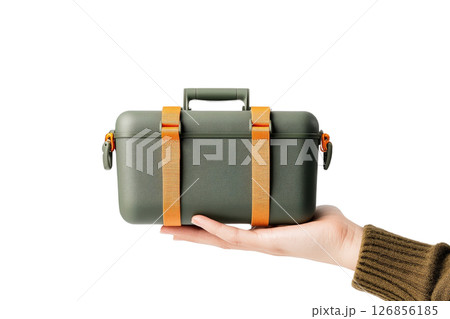 Close up of a human hand firmly grasping and holding a sturdy durable camping gear box or container for an outdoor adventure or The box appears to be made of a rugged 126856185