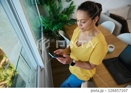 Businesswoman Using Smartphone in Cozy Home Office Setting 126857107