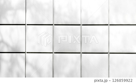 White architectural wall tiles with soft natural shadows in grid layout 126859922