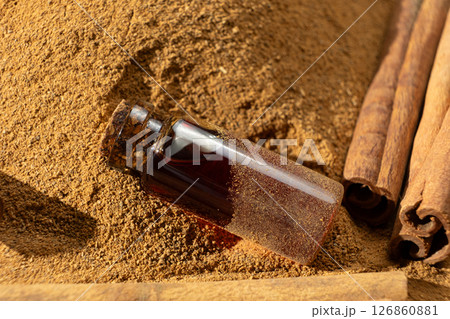 Natural cinnamon essential oil in a glass bottle close-up. 126860881