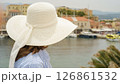 Tourist wearing white sun hat looking at chania venetian harbour in crete, greece 126861532
