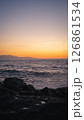 Waves crashing on rocks at sunset with birds flying over the ocean 126861534